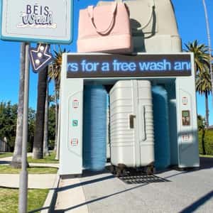 Luggage Bags Pass on Car Wash Rollers in a fake-out-of-home ad of BÉIS