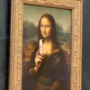 Mona Lisa Shows Serum to Visitors in a fake-out-of-home ad of Caudalie