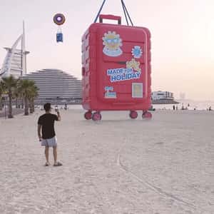 Suitcase on Inflatable Lands on Beach in a fake-out-of-home ad of Centrepoint
