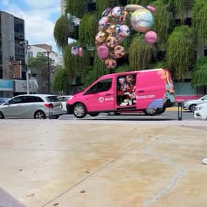 Van Lifted by Balloons in a fake-out-of-home ad of Enviaflores