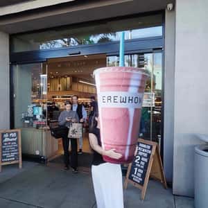 Woman Carries Smoothie Cup in a fake-out-of-home ad of Erewhon