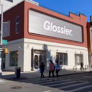 Lip Balm Fell from Store Facade in a fake-out-of-home ad of Glossier