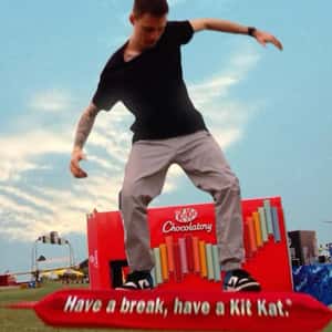 Man Surfs on Chocolate Bar in a fake-out-of-home ad of KitKat