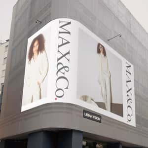 Digital Screen Spills Christmas Balls in a fake-out-of-home ad of MAX& Co.