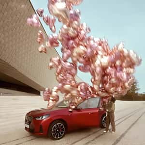 Red Car Releases Heart-shaped Balloons in fake-out-of-home ad of BMW