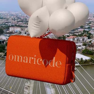 Purse Carried by Balloons in a fake-out-of-home ad of Omaricode