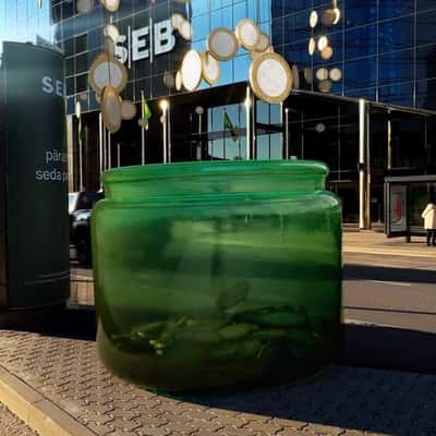 Hanging Coins Fell on Green Jar in a fake-out-of-home ad of SEB