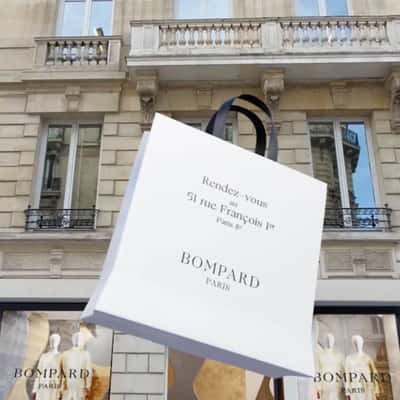 Shopping Bags Emerges from Store in a fake-out-of-home ad of Bompard