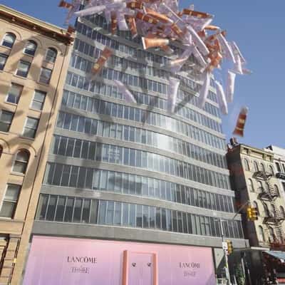 Lip Gloss Rain Down From Building in a fake-out-of-home ad of Lancôme
