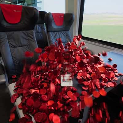 Red Coins Burst Out of the Phone in a fake-out-of-home ad of ÖBB