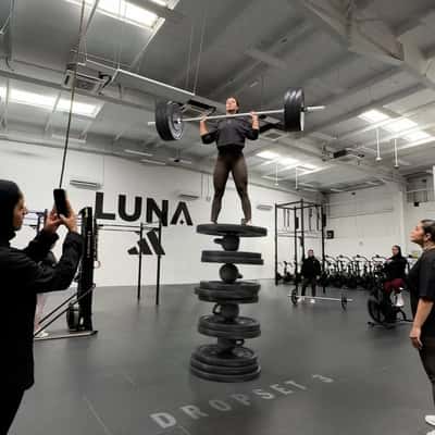 Woman Balancing on Piled Weight Plates in a fake-out-of-home ad of Adidas