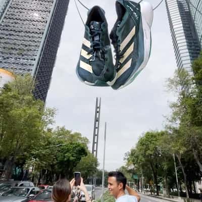 Running Shoes Hang in Between Skyscrapers in a fake-out-of-home ad of Adidas