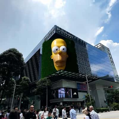 Yellow Hand Shows Sneaker at Facade in a fake-out-of-home ad of Adidas