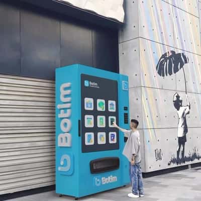 Man Gets Card from Vending Machine in a fake-out-of-home of Botim