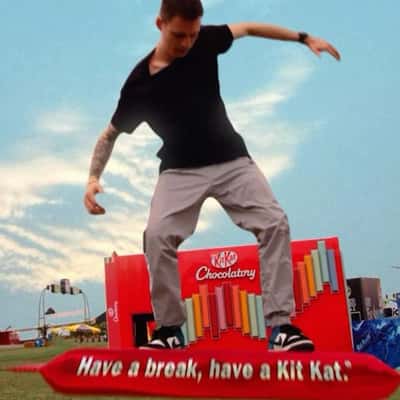 Man Surfs on Chocolate Bar in a fake-out-of-home ad of KitKat